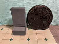 Wobble cushion standing next to two gray yoga blocks
