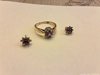 Ring and both earrings displayed on white surface