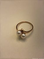Bypass ring top view showing two pearls and gold setting