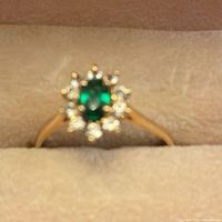 Front view of ring showing emerald and diamond halo