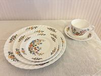 Stacked view showing dinner, salad, bread plates with cup and saucer