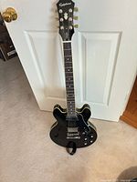 Full view of Epiphone ES-339 guitar leaning against door