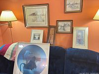 Assorted framed prints on couch showing variety of sizes and subjects