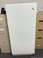 Front view of closed white Frigidaire upright freezer