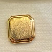 Front of gold-plated octagonal tie tack showing brushed centre and polished border