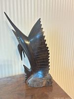 Front angled view of the carved sailfish sculpture on base