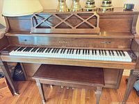 Front view of Kawai upright piano with bench beneath keyboard