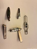 All five tie clips arranged on surface