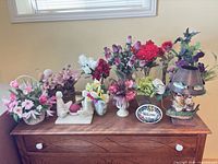 Full lot on dresser showing all artificial flower arrangements, lamp, plaque and candle holder