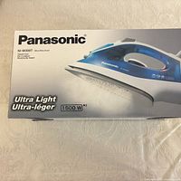 Retail box front showing Panasonic NI-M300T steam iron image and 1500 W rating