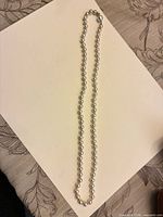 full view of single-strand simulated pearl necklace laid out