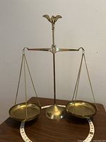 Full view of brass balance scale with two pans and base