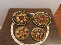 All four mandala cloisonné brass plates displayed on table