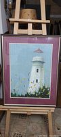 Full view of framed lighthouse painting on easel
