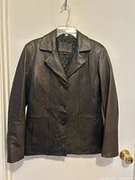 Front view of Jessica leather jacket on hanger showing full design