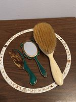 Mirror, comb, and brush grouped on tabletop