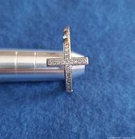 Front view showing pavé stone cross and silver tone