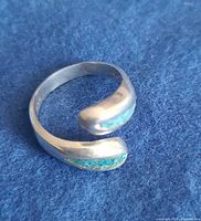 Ring laid flat showing open band and both turquoise inlays