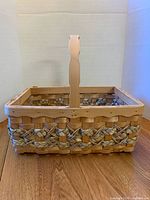 Full view of woven wood basket showing handle and decorative band