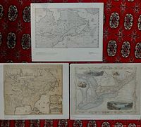 Three reproduction maps laid out on patterned red fabric background