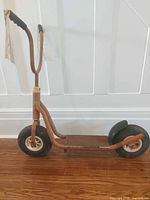 Full side view of brown metal scooter showing overall design and size