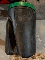 Full view of black plastic mixing container with green lid