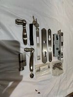 Full contents arranged on cloth: lever handles, cylinder, lock body, plates, keys, screws