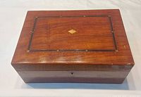Closed inlaid wooden box top view showing inlay and diamond motif