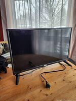 Front view of RCA 24-inch TV/DVD combo on wood table, power cord visible