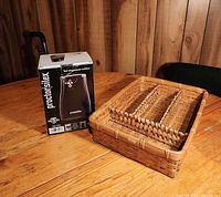 Boxed Proctor Silex electric can opener beside wicker utensil tray