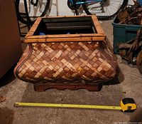 Square wicker planter showing front and measuring tape indicating about 24 in width