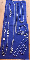 All ten jewelry pieces arranged on blue cloth