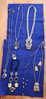 All eight jewelry items arranged on blue cloth