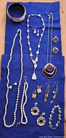 All twelve jewelry items laid out on blue cloth