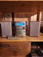 Front view of JVC stereo main unit with two speakers and remote