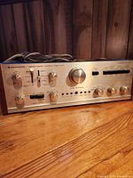 Front view of Kenwood stereo amplifier showing controls and wood side panels