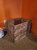 Exterior view of wooden crate showing slatted sides and corner supports