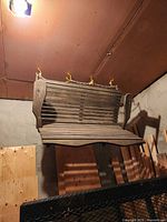 Front view of brown wooden slatted porch swing bench hanging from chain