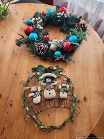 Wreath and metal welcome sign on table