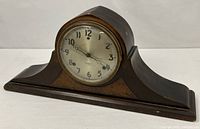 Full front view of Gilbert camelback wooden mantel clock
