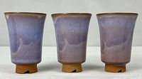Front view of three matching Hagi Yaki tumblers showing glaze and notched feet