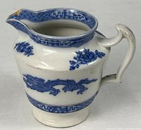 Full view of pitcher showing blue dragon motif and overall form