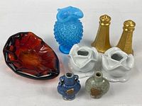 Group shot of all eight items: glass leaf dish, blue hobnail vase, gold shakers, porcelain rose candle holders, two snuff bottles
