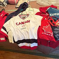 Overview of eight Canada-themed garments laid out on surface