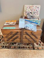 Box open showing interior fabric lining, thread spools, Singer packs, buttons, basket