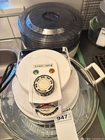 Top view of Deco Sonic convection roaster with glass bowl and control head; dehydrator trays stacked behind