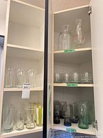Cabinet showing assorted tumblers and one vase