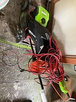 Top view of mower with bundled red/orange extension cords on deck