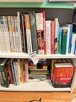 Two shelves filled with assorted cookbooks, gardening and fiction titles