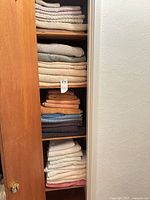 Stacked folded towels on closet shelves